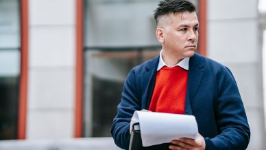 A serious man holding papers, dressed professionally in an urban environment. — 4 Things Every Landlord Should Know