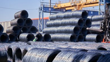 Large stacks of steel wire coils stored outdoors at an industrial site under bright daylight. — 5 Things to Consider Before S