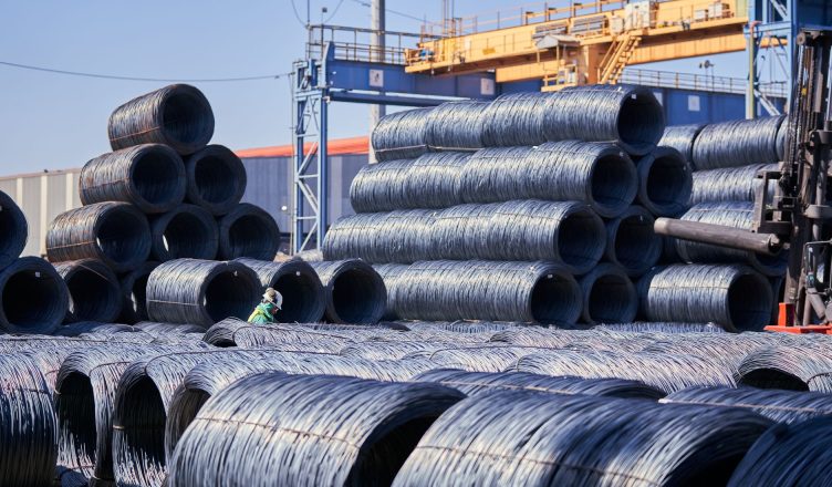 Large stacks of steel wire coils stored outdoors at an industrial site under bright daylight. — 5 Things to Consider Before S