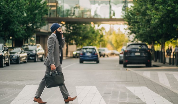 Sikh businessman with a turban crossing a city street on a zebra crossing, carrying a briefcase. — Advantages of drinking Dom