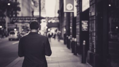 Man in a suit walking down a city street in a lonely, urban setting. — Benefits of Image retouching services to photographers