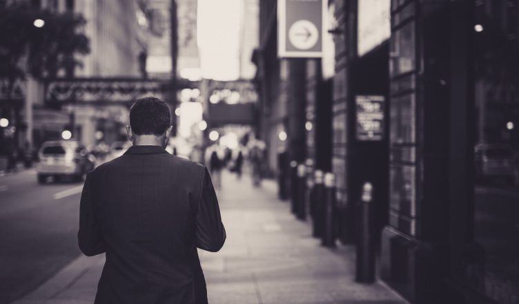 Man in a suit walking down a city street in a lonely, urban setting. — Benefits of Image retouching services to photographers