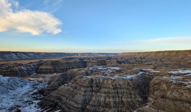 Wide view of the rugged Badlands landscape with snow patches under a clear blue sky. — Buy Quality Chairs for Your Office Use