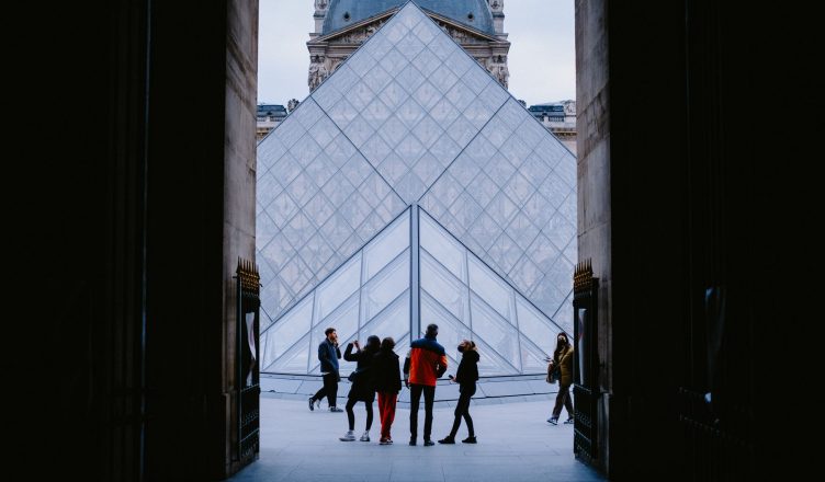 Tourists explore the stunning Louvre Pyramid in Paris, a famed architectural landmark. — Costa Rica All-Inclusive Surfing: Ex
