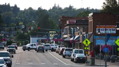 Lively urban street with cars, shops, and pedestrians during daytime. — Discover the many benefits of using simulation modell