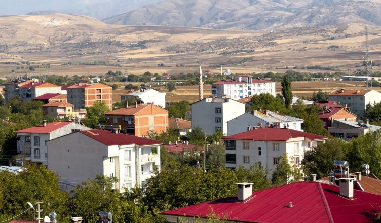 Panoramic view of Kovancılar town with red-roofed buildings against a backdrop of mountains in Elazığ, Türkiye. — Essential F