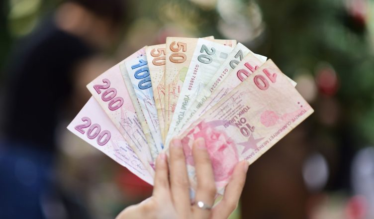 Hand holding multiple denominations of Turkish Lira banknotes outdoors. — Explain the framework of the iot platform