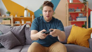 A young man intensely playing video games in a modern living room setting. — Exploring the W88 Live Lottery: Fast-Paced Fun a