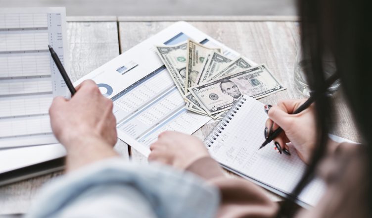 Two people working on financial documents and dollar bills for budgeting. — Finest Options for the Smartest Debt Recovery Now