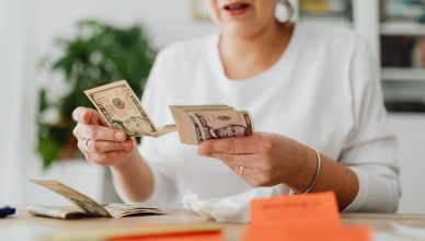 A woman sits indoors counting cash at her office desk, focusing on finances. — Folio Number: Meaning and benefits