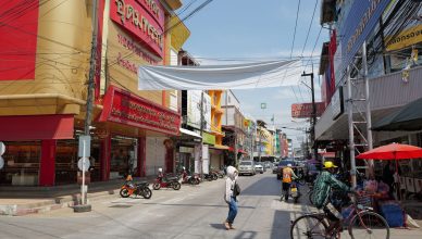 Lively urban street in Thailand with people, shops, and traffic under a sunny sky. — Forex Training: How Should You Begin Tra