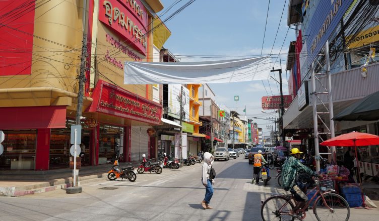 Lively urban street in Thailand with people, shops, and traffic under a sunny sky. — Forex Training: How Should You Begin Tra