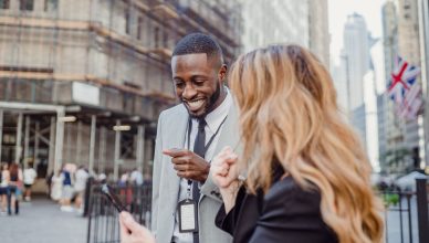 Two business professionals engage in lively conversation on an urban street, sharing insights. — Grow your online business te