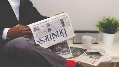 Businessman reading a financial newspaper at a desk, highlighting finance and commerce theme. — Here's Why Every Tenant Shoul