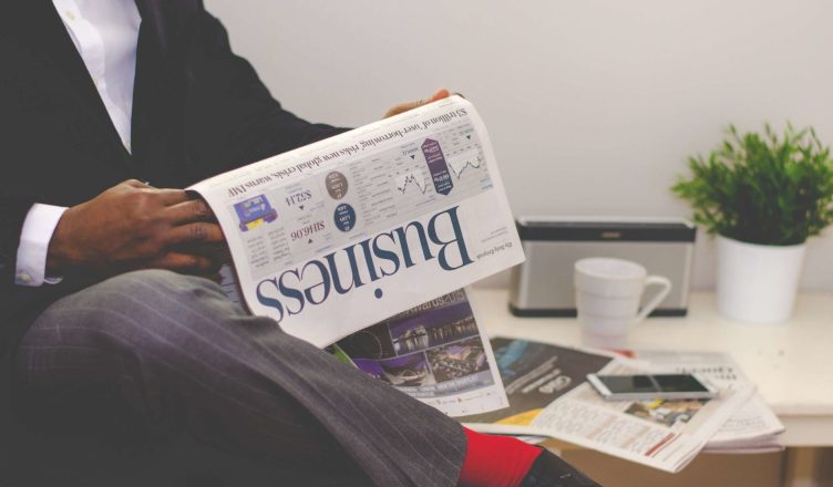Businessman reading a financial newspaper at a desk, highlighting finance and commerce theme. — Here's Why Every Tenant Shoul