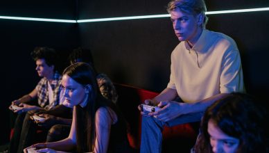 Group of focused teenagers playing video games indoors, immersed in teamwork and concentration. — HWID Spoofing: The Key to B