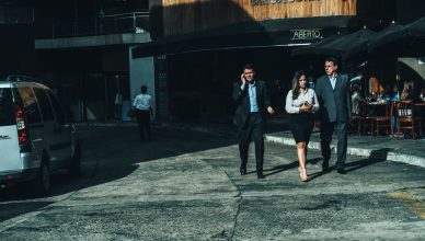 Three business professionals walk along a city street outside a cafe. — In what ways does the Online Teacher Training Course