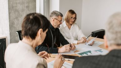 Team of professionals in office analyzing financial documents for business strategy. — Is Selling Merchant Services A Good Jo