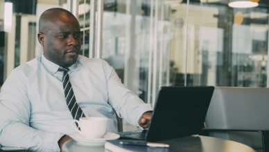 Focused businessman uses laptop in stylish cafe, sipping coffee. Perfect for business or lifestyle themes. — Making of Mold B