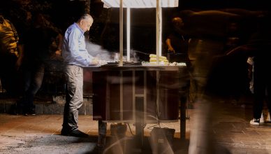 Street vendor cooking food at night with blurred people passing by. — Nangs Delivery Brisbane: Setting the Standard for Urban