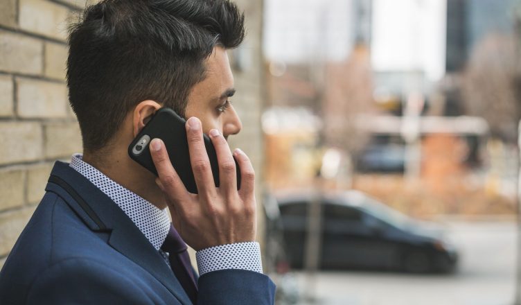 Professional man in suit making a phone call outside in city setting. — Need money instantly to come out of the problem: