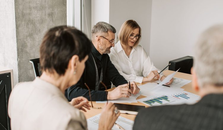 Team of professionals in office analyzing financial documents for business strategy. — Preparing To Buy a Vacation Home