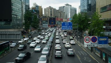 Heavy traffic on a busy Shanghai street lined with skyscrapers and billboards during the day. — Sell Platinum In New York