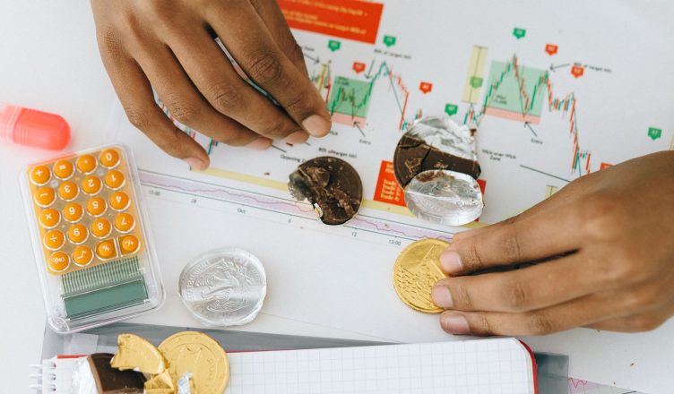 Analyzing financial charts with a calculator and chocolate coins. — Six Tips That Can Improve Performance of Novice Traders