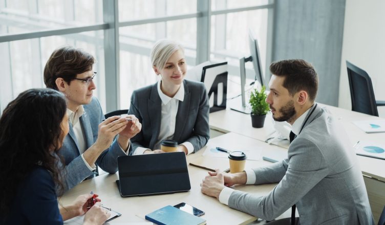 Group of professionals having a discussion in a modern office setting with natural light. — The current revolution of the ind