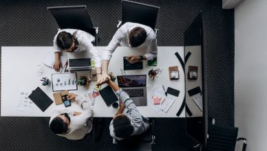 High angle view of colleagues collaborating around a conference table in a modern office setting. — The Current State of St.