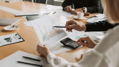Professionals reviewing financial graphs and charts during a meeting. — The Essential Steps to Safely Ordering Testosterone O