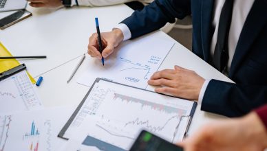 Professionals analyzing financial charts in a corporate setting. — Things that nobody told you about online poker!!