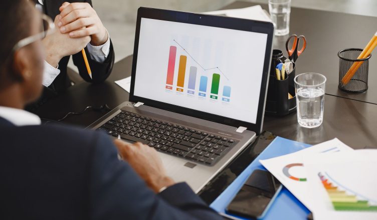 Two professionals analyzing a business graph on a laptop during a meeting. — Types of Life Insurance Plans for Your Child