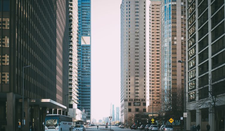 Vibrant city street scene with tall skyscrapers and city life full of cars and pedestrians. — Understanding Property and Casu