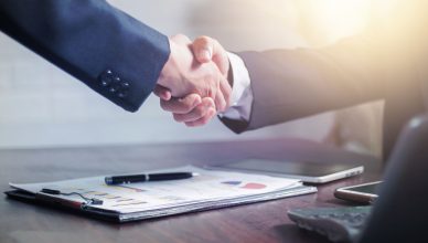 Professional handshake agreement over business charts in an office setting. — What are some important elements of Digital Tra