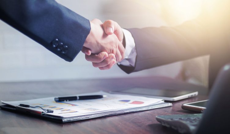 Professional handshake agreement over business charts in an office setting. — What are some important elements of Digital Tra