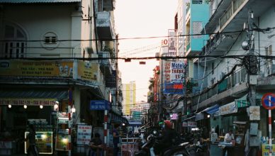 Colorful busy street scene in Cần Thơ, Vietnam with vibrant signs and people. — What is Waves Cryptocurrency?