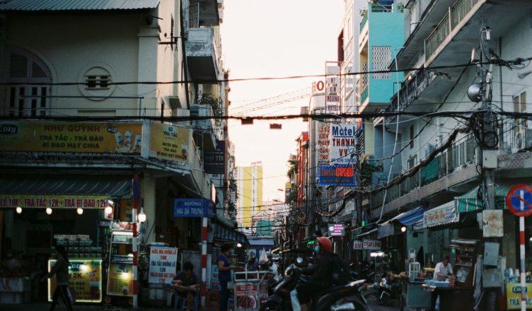 Colorful busy street scene in Cần Thơ, Vietnam with vibrant signs and people. — What is Waves Cryptocurrency?