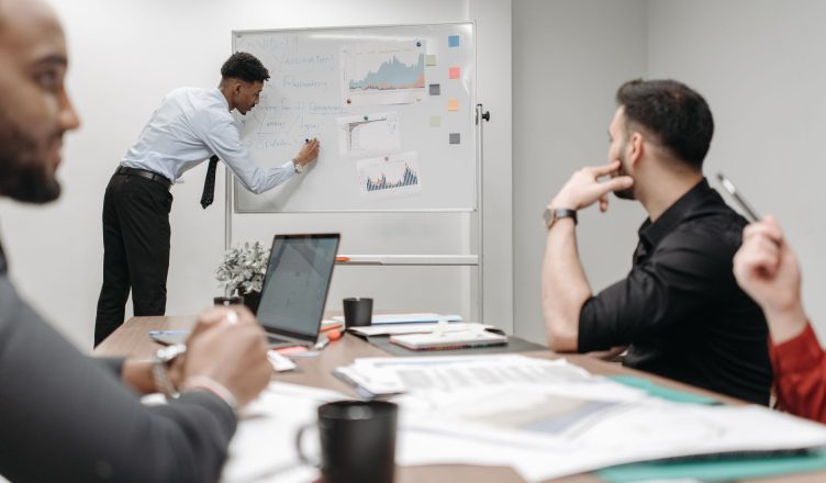 Colleagues in a business meeting discussing data and strategies at the office. — What kind of Tax Calculations You Can Think