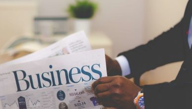 Close-up of a businessman reading a newspaper indoors, focusing on business headlines. — Why is EMI Calculator a Must Before