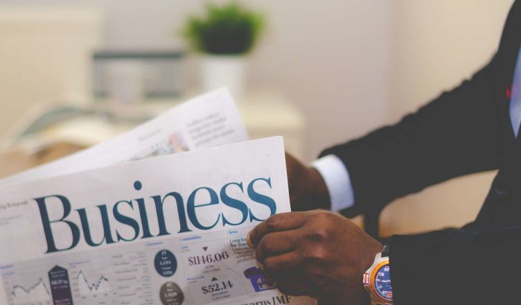 Close-up of a businessman reading a newspaper indoors, focusing on business headlines. — Why is EMI Calculator a Must Before