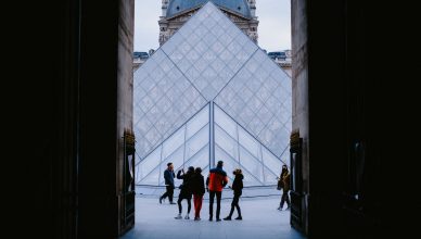 Tourists explore the stunning Louvre Pyramid in Paris, a famed architectural landmark. — Why you should Travel to Space for Y